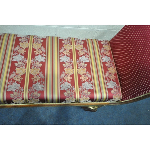 164 - A REPRODUCTION ITALIAN STYLE WINDOW SEAT, with scrolled armrests, raised on winged padded feet, stri... 