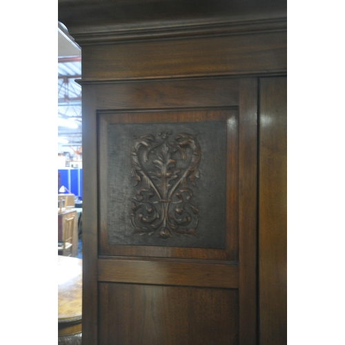 196 - AN EARLY 20TH CENTURY WARDROBE, with two foliate panels, flanking a bevelled mirror door, above two ... 