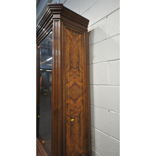 221 - A 20TH CENTURY MAHOGANY AND WALNUT BREAKFRONT BOOKCASE, fitted with four bevelled glass doors, atop ... 