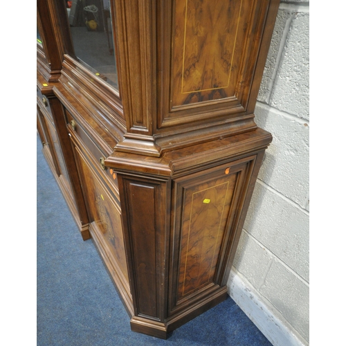 221 - A 20TH CENTURY MAHOGANY AND WALNUT BREAKFRONT BOOKCASE, fitted with four bevelled glass doors, atop ... 