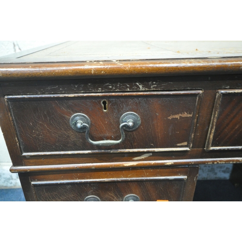 224 - A 20TH CENTURY MAHOGANY TWIN PEDESTAL DESK, with a leather writing surface, fitted with eight assort... 