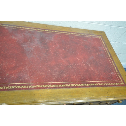 244 - A 20TH CENTURY OAK TWIN PEDESTAL DESK, with an oxblood leather writing surface, fitted with nine ass... 