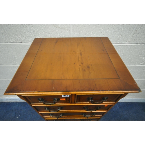 245 - A REPRODUCTION YEW WOOD TALL CHEST OF EIGHT ASSORTED DRAWERS, with a single brushing slide, raised o... 