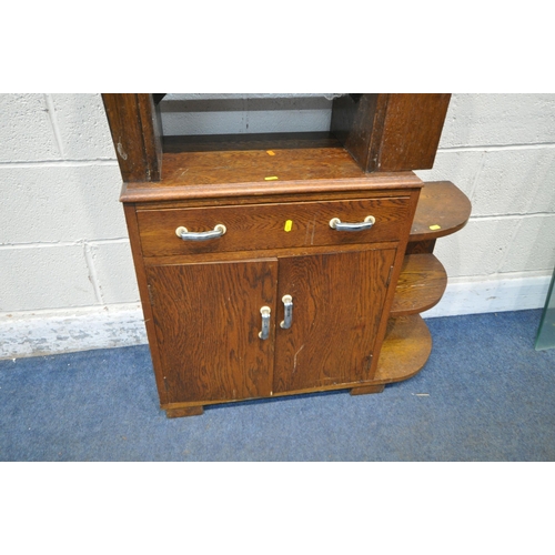 265 - AN ART DECO OAK SIDE TABLE, with a double sided drawer, shelves to one end, and a magazine rack to t... 