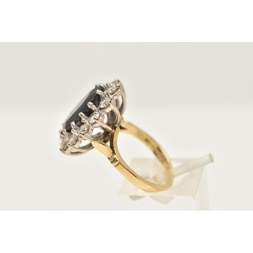 412 - AN 18CT GOLD LARGE SAPPHIRE AND DIAMOND CLUSTER RING, of an oval form, set with a central oval cut d... 