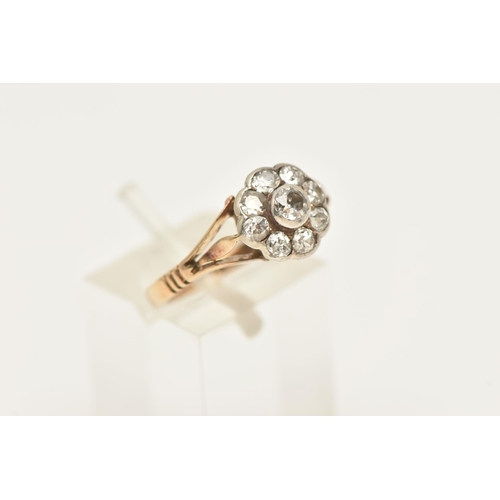 450 - AN EARLY 20TH CENTURY DIAMOND FLORAL CLUSTER RING, nine old cut diamonds, bezel set in a white metal... 