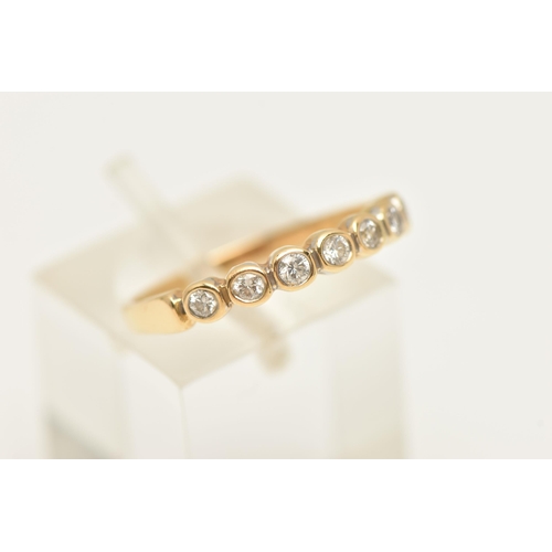 451 - A MODERN DIAMOND BAND RING, seven round brilliant cut diamonds bezel set in yellow gold, approximate... 