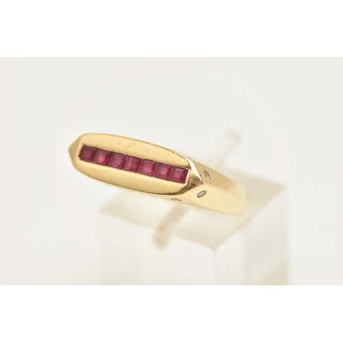 453 - A YELLOW METAL GEM SET SIGNET RING, a rectangular form signet ring, channel set to the top with seve... 