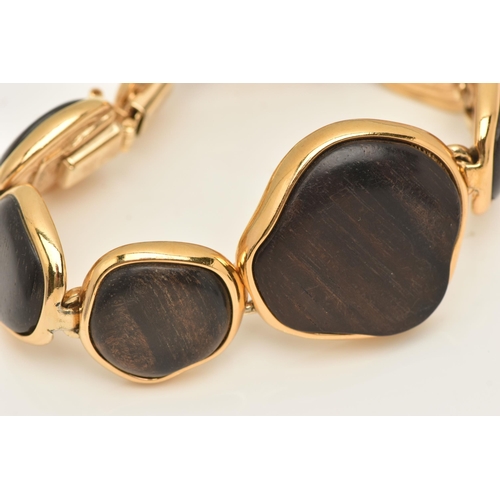 458 - A 'YVES SAINT LAURENT' BRACELET, designed as abstract wooden panels with gold plated surround and go... 