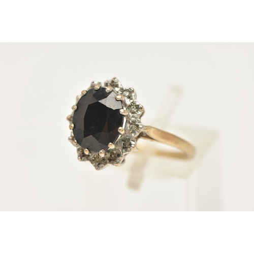 461 - A 9CT GOLD SAPPHIRE CLUSTER RING, of an oval form, set with a central oval cut deep blue sapphire, c... 