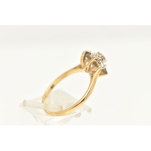 463 - A YELLOW METAL DIAMOND CLUSTER RING, set with a central round brilliant cut diamond, within a surrou... 