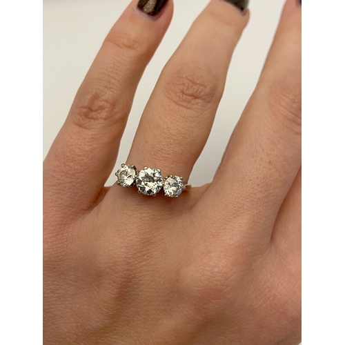 413 - A PLATINUM THREE STONE DIAMOND RING, three old cut diamonds, each claw set, central stone measuring ... 