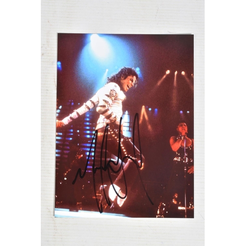 197 - A SIGNED 6   X 8   PHOTOGRAPH OF MICHAEL JACKSON ON STAGE, signed in black marker and in its plastic... 