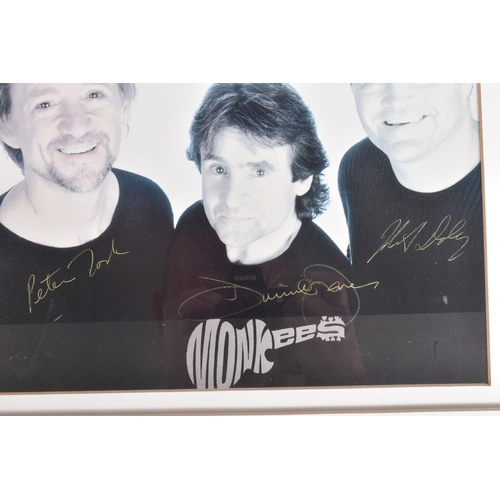 205 - TWO FRAMED SIGNED PHOTOGRAPHS OF BAND GROUPS, to include a black and white photograph of The Monkees... 