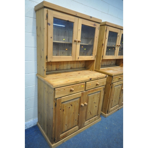 151 - TWO MODERN PINE DRESSERS, the top section with double glass doors, atop a base with two drawers, and... 