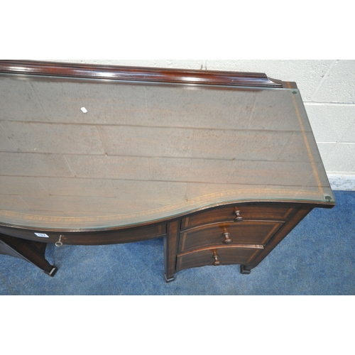 167 - AN EDWARDIAN MAHOGANY SERPENTINE DESK, with an arrangement of seven drawers, on square tapered legs ... 