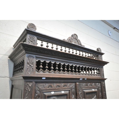 174 - AN EARLY 20TH CENTURY FRENCH CARVED OAK TWO DOOR CUPBOARD, the Breton detail to the doors, above a s... 