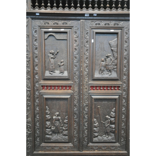 174 - AN EARLY 20TH CENTURY FRENCH CARVED OAK TWO DOOR CUPBOARD, the Breton detail to the doors, above a s... 