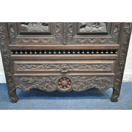 174 - AN EARLY 20TH CENTURY FRENCH CARVED OAK TWO DOOR CUPBOARD, the Breton detail to the doors, above a s... 