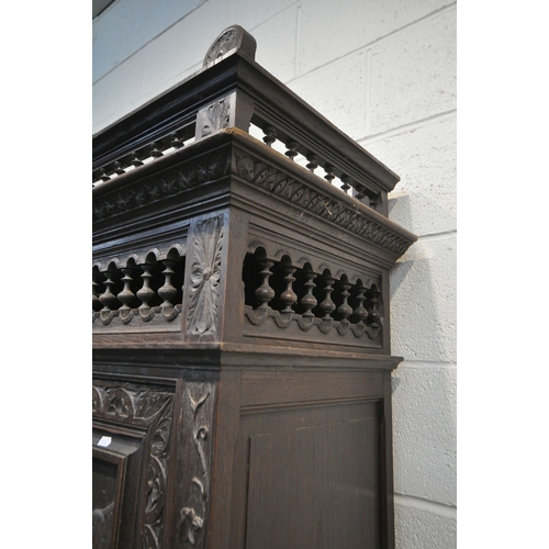 174 - AN EARLY 20TH CENTURY FRENCH CARVED OAK TWO DOOR CUPBOARD, the Breton detail to the doors, above a s... 