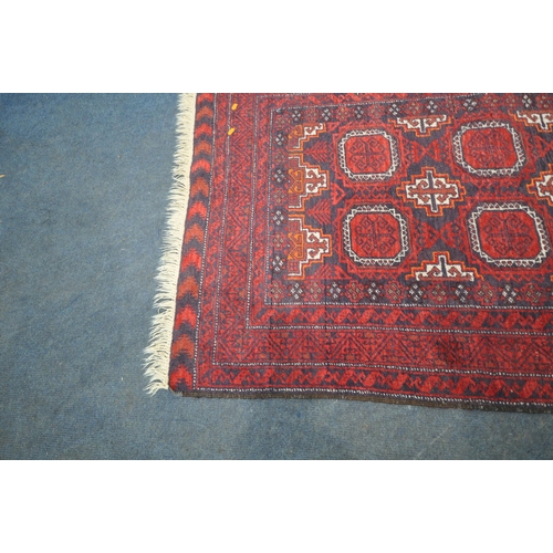 188 - A RED GROUND RECTANGULAR RUG, with eight medallions, repeating geometric patterns, surrounded by a m... 