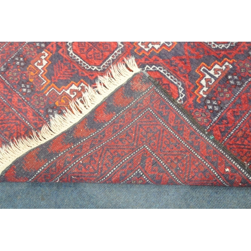 188 - A RED GROUND RECTANGULAR RUG, with eight medallions, repeating geometric patterns, surrounded by a m... 