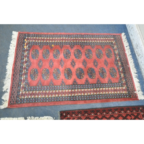 189 - A RED GROUND RECTANGULAR RUG, with sixteen medallions, surrounded by a multi-strap border, 142cm x 9... 