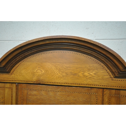 208 - A 20TH CENTURY OAK WARDROBE, with an arched cornice, an oval mirrored door, above a single drawer, w... 