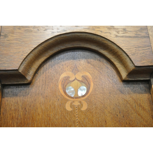 208 - A 20TH CENTURY OAK WARDROBE, with an arched cornice, an oval mirrored door, above a single drawer, w... 