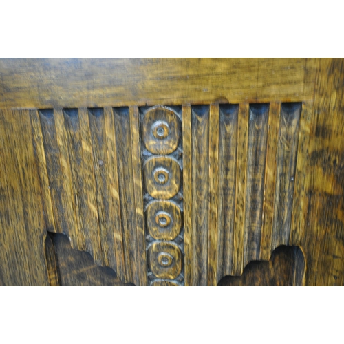 221 - A 20TH CENTURY OAK DOUBLE DOOR WARDROBE, with foliate and geometric carved details, a fitted interio... 