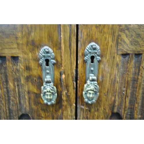 221 - A 20TH CENTURY OAK DOUBLE DOOR WARDROBE, with foliate and geometric carved details, a fitted interio... 