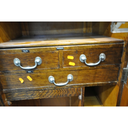 221 - A 20TH CENTURY OAK DOUBLE DOOR WARDROBE, with foliate and geometric carved details, a fitted interio... 