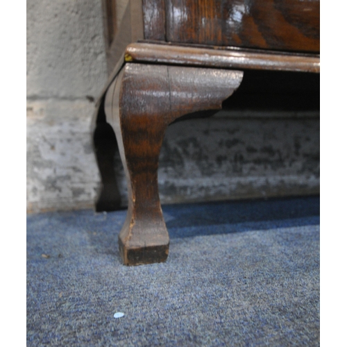 231 - A 20TH CENTURY OAK DISPLAY CABINET, the double lead glazed doors enclosing glass shelves, raised on ... 