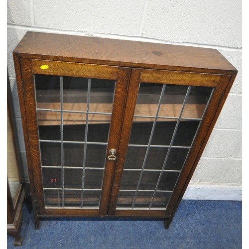 231 - A 20TH CENTURY OAK DISPLAY CABINET, the double lead glazed doors enclosing glass shelves, raised on ... 