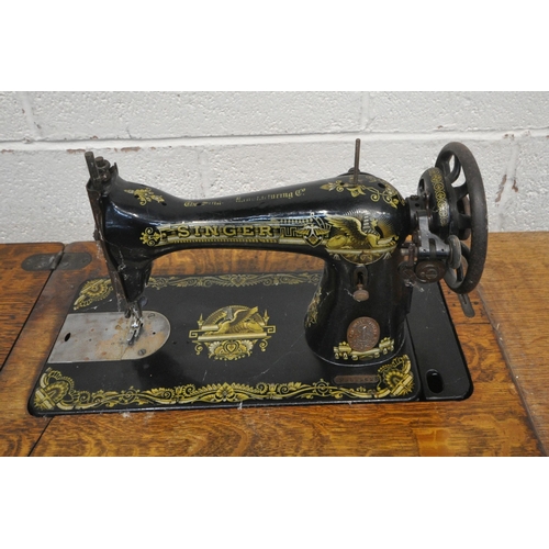 233 - A 20TH CENTURY OAK CASED TREADLE SINGER SEWING MACHINE, raised on a cast iron frame, width 92cm x de... 