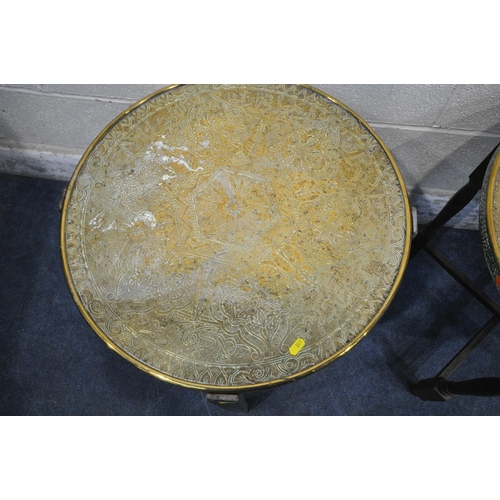 241 - TWO CIRCULAR BRASS TRAY TOP TABLES, with intricate designs, raised on folding bases, tallest table d... 