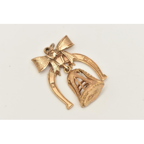 403 - A 9CT GOLD CHARM, a yellow gold horseshoe with a bow, fitted with a bell dropper and a couple standi... 