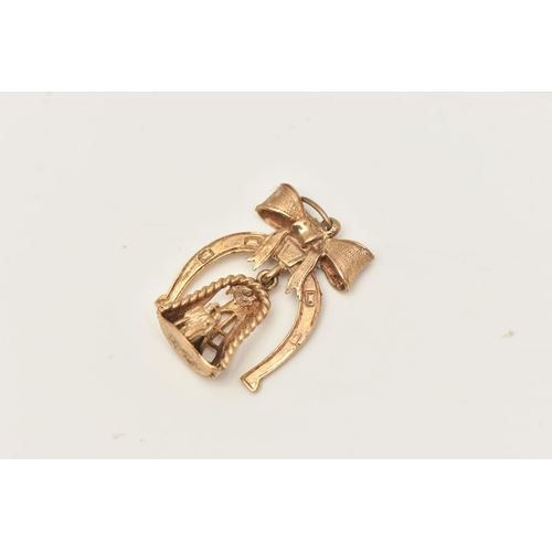 403 - A 9CT GOLD CHARM, a yellow gold horseshoe with a bow, fitted with a bell dropper and a couple standi... 