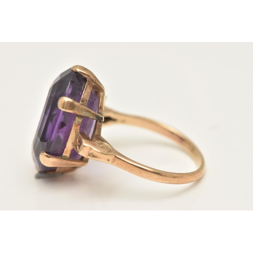 417 - A LARGE AMETHYST DRESS RING, an oval cut deep purple amethyst, six prong set in yellow metal, scroll... 