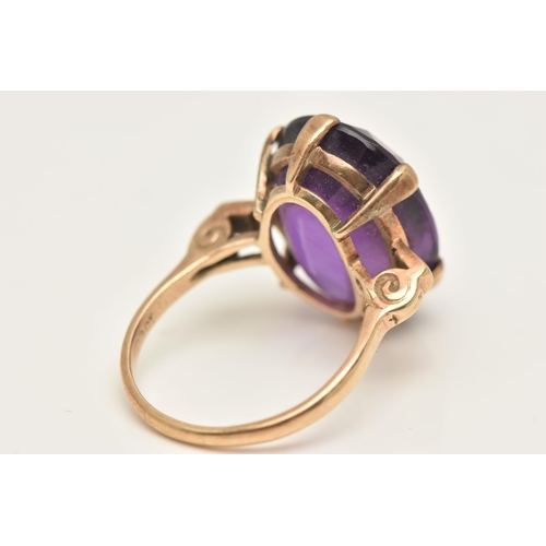 417 - A LARGE AMETHYST DRESS RING, an oval cut deep purple amethyst, six prong set in yellow metal, scroll... 