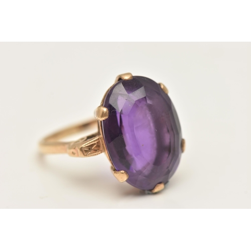 417 - A LARGE AMETHYST DRESS RING, an oval cut deep purple amethyst, six prong set in yellow metal, scroll... 