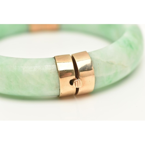 420 - A JADE BANGLE, a dyed jade bangle with yellow metal hinge and clasp fittings, approximate width 15mm... 