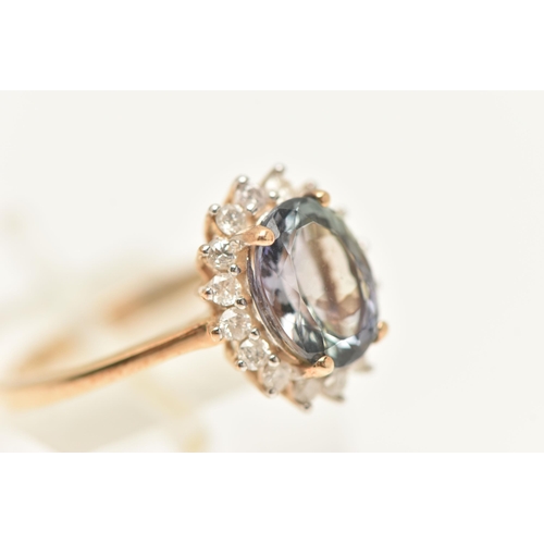 449 - A 9CT GOLD CLUSTER RING, of an oval form, set with an oval cut mystic topaz, four claw set within a ... 