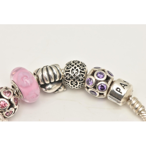 481 - A PANDORA CHARM BRACELET, to include a bracelet with fourteen charms and two hinged spacer charms, b... 