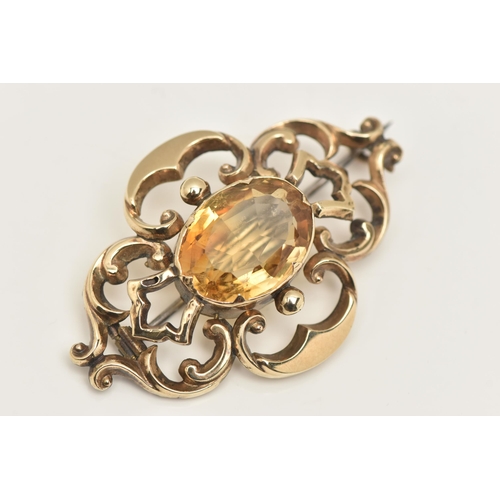 568 - A YELLOW METAL CITRINE BROOCH, open work brooch set with a central oval cut Citrine, collet set to t... 