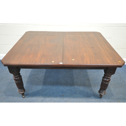 156 - AN EARLY 20TH CENTURY MAHOGANY WIND OUT DINING TABLE, with two additional leaves, raised on turned l... 