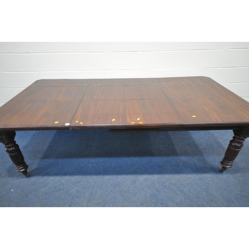 156 - AN EARLY 20TH CENTURY MAHOGANY WIND OUT DINING TABLE, with two additional leaves, raised on turned l... 