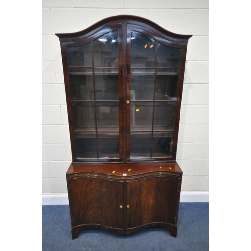 163 - A 20TH CENTURY MAHOGANY BOOKCASE, the arched top with double glazed doors, atop a serpentine base, w... 