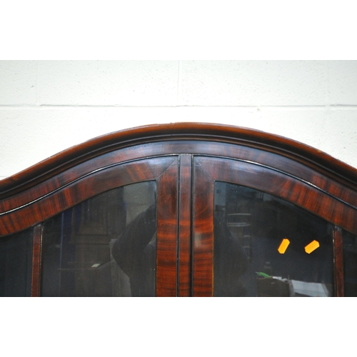 163 - A 20TH CENTURY MAHOGANY BOOKCASE, the arched top with double glazed doors, atop a serpentine base, w... 