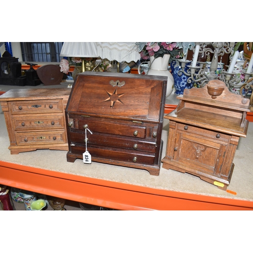 834 - A MINIATURE WRITING BUREAU AND TWO MINIATURE SETS OF DRAWERS comprising a wooden miniature bureau wi... 